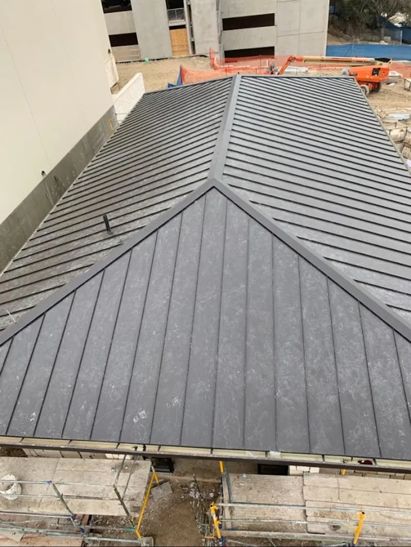 Commercial metal roof construction with crane equipment in Fairbanks